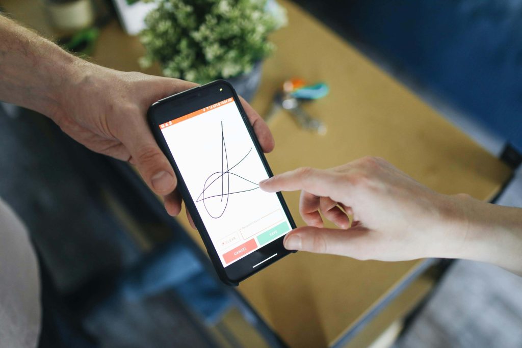 Ruka koja digitalno potpisuje na mobitelu